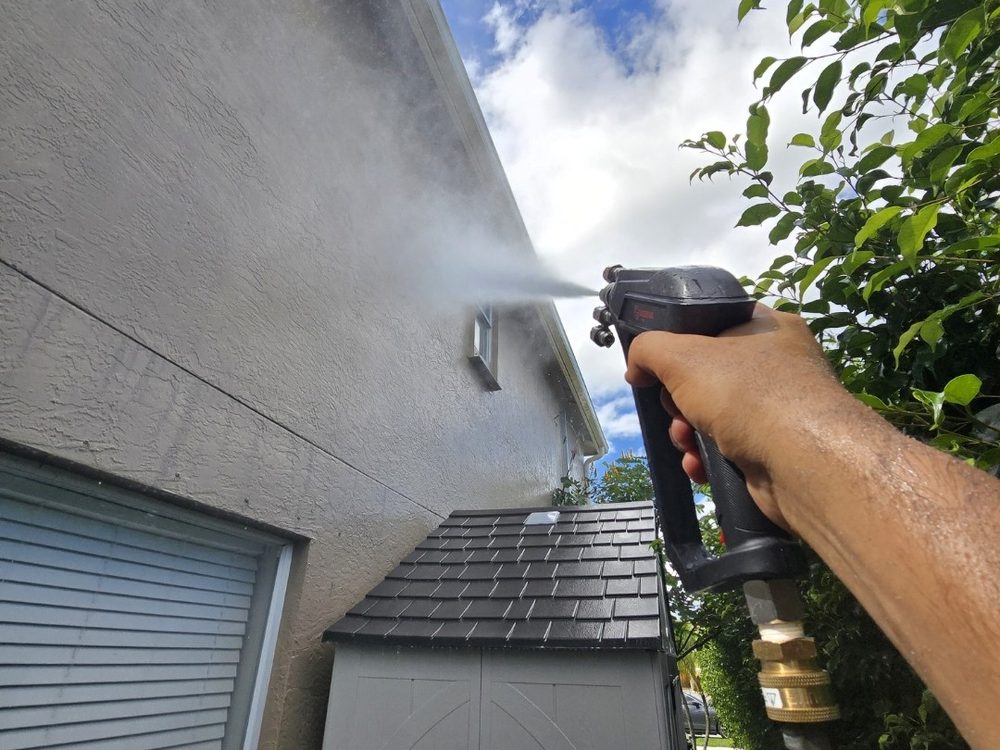 Soft washing the stucco wall of a two-story home